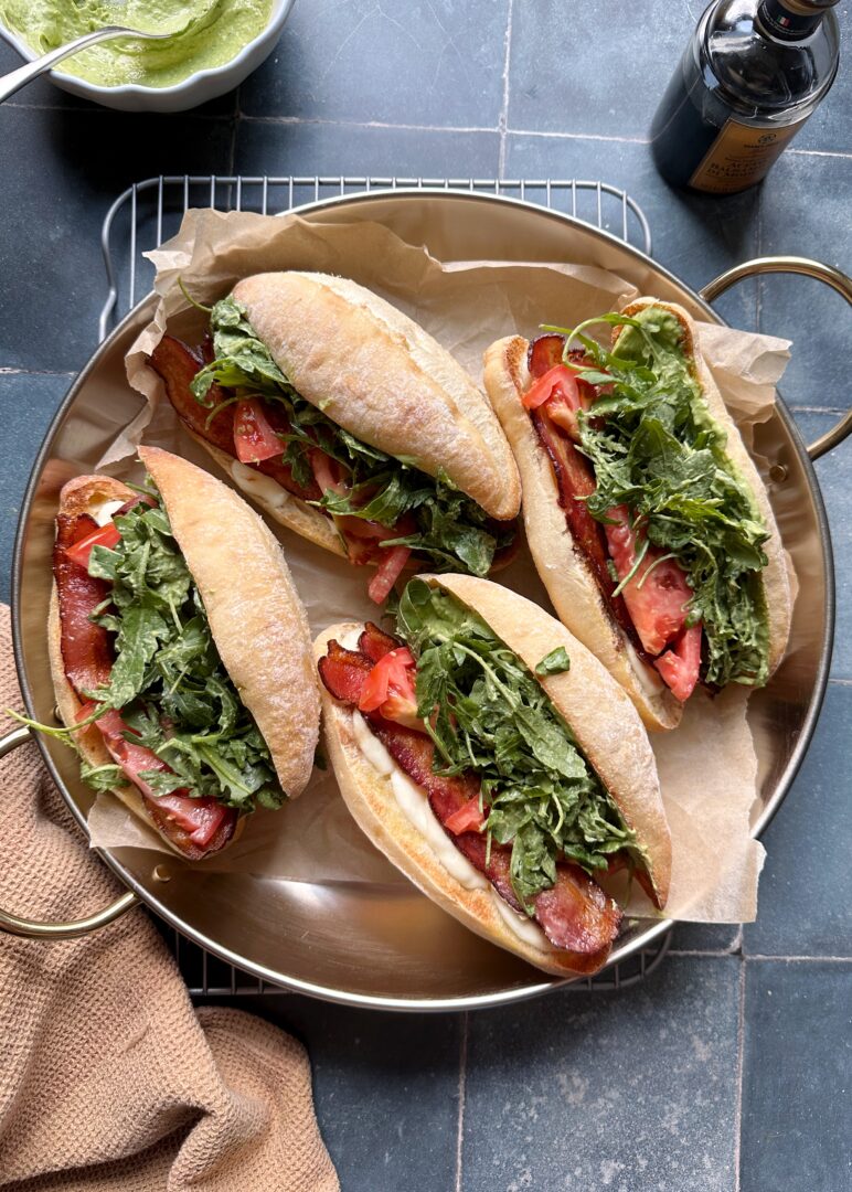 silver tray of green goddess caprese melt sandwiches with bacon and arugula
