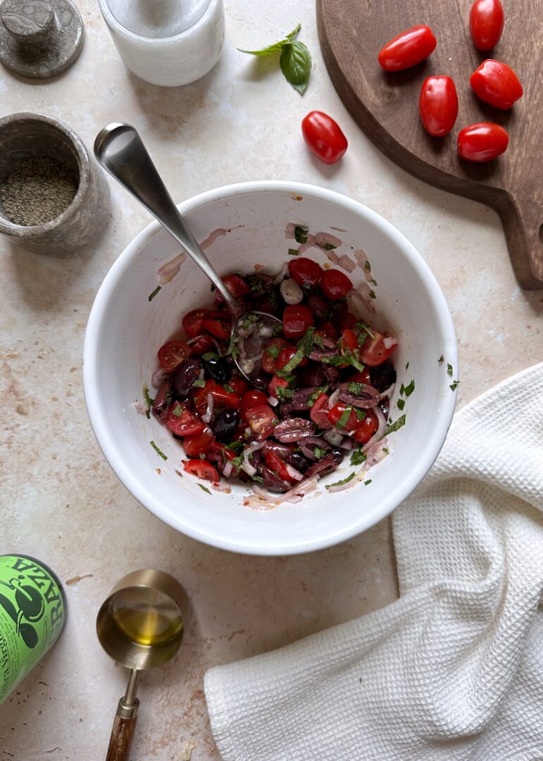 tomato and kalamta salad in white mixing bowl