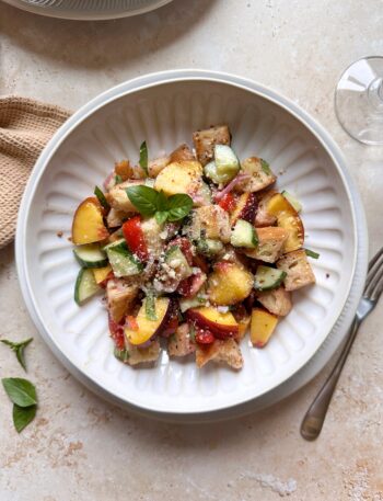 tomato cucumber peach panzanella salad with grated parmesan