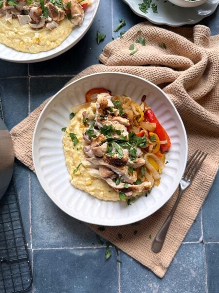 bowl of Cajun chicken and polenta with peppers and onions
