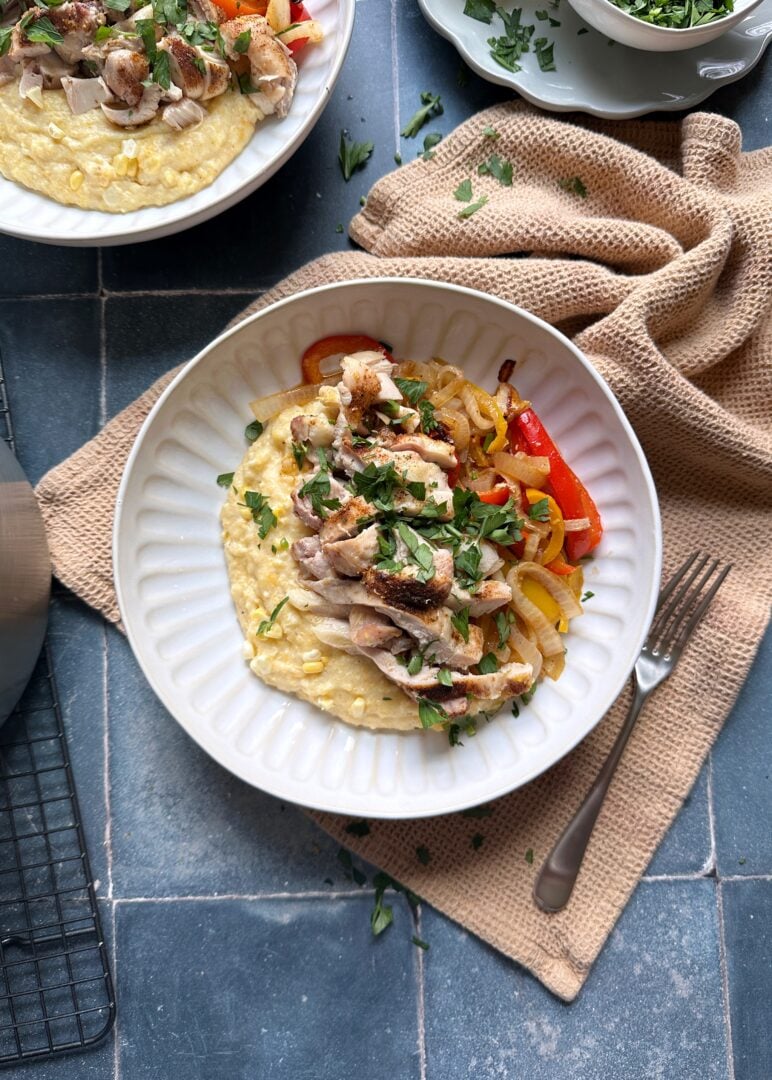 bowl of Cajun chicken and polenta with peppers and onions