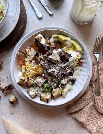 bowl of grilled steak caesar salad with summer produce