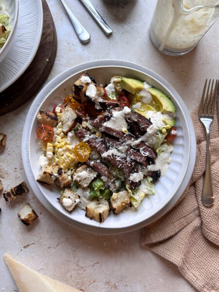 bowl of grilled steak caesar salad with summer produce