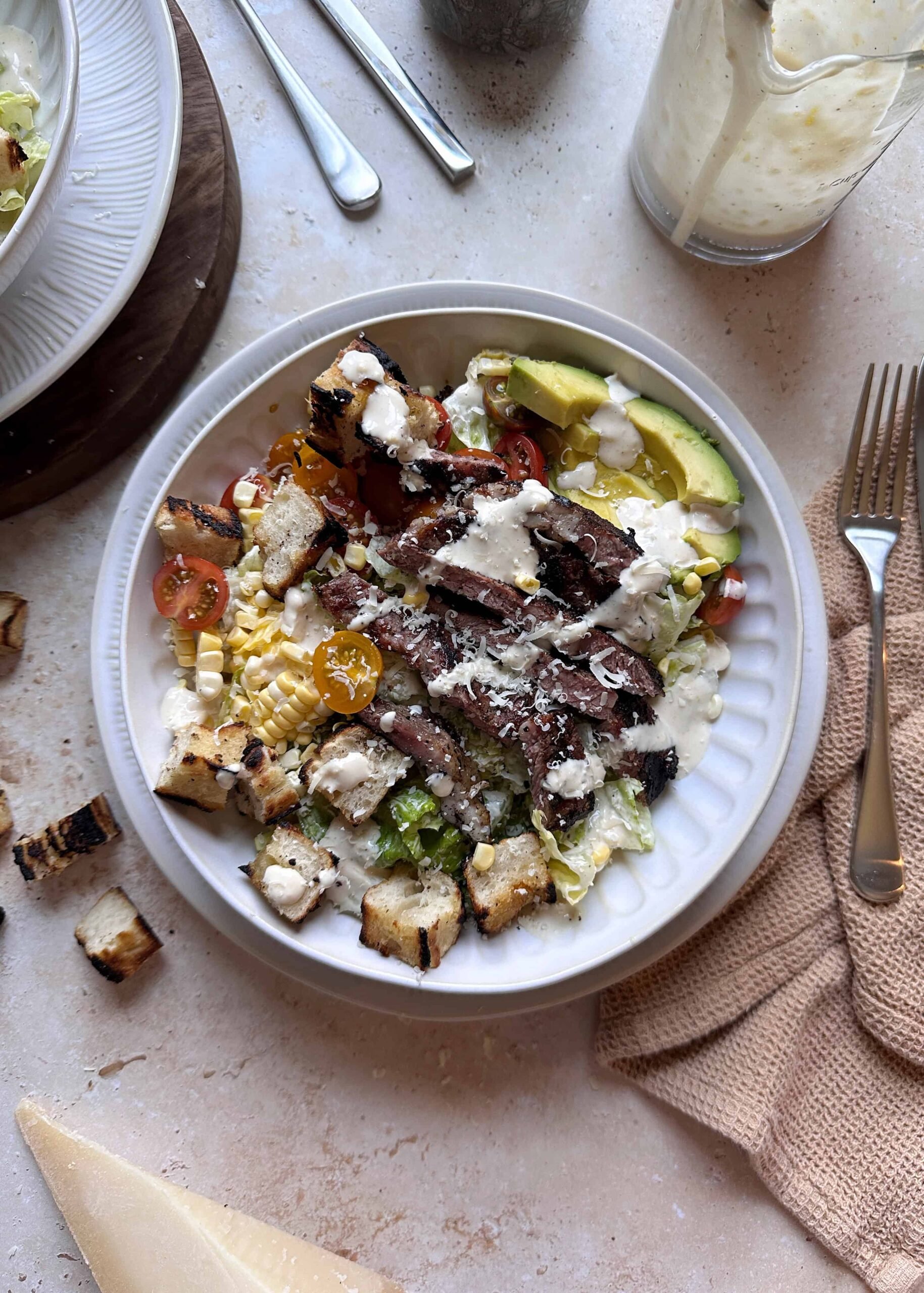 bowl of grilled steak caesar salad with summer produce