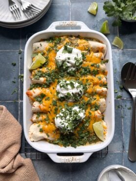 cheesy green chile chicken enchiladas in casserole dish