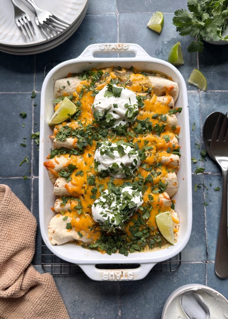 cheesy green chile chicken enchiladas in casserole dish