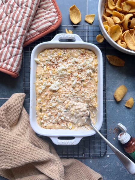creamy elote dip with crumbled cotija and tajin sprinkled on top