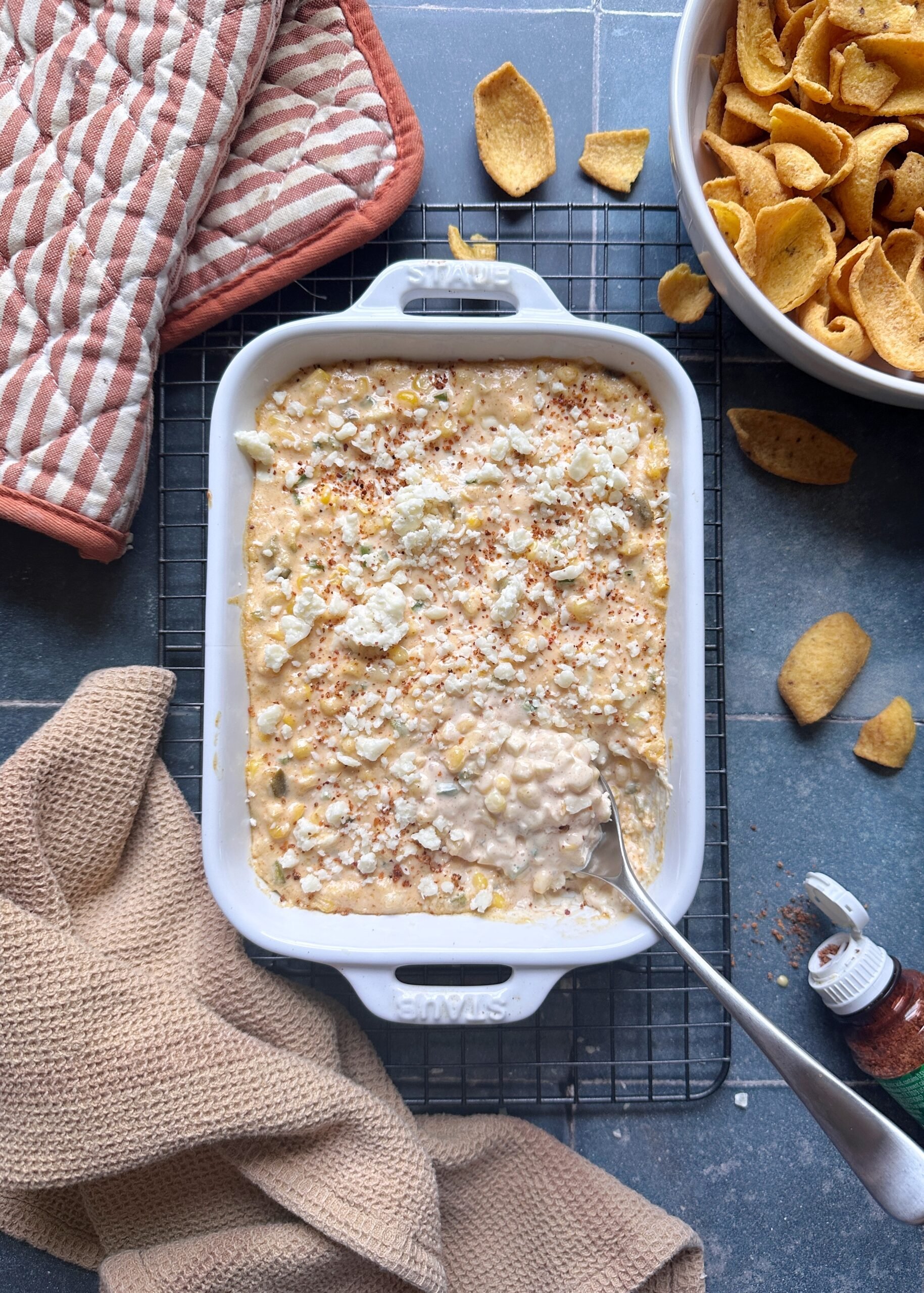 creamy elote dip with crumbled cotija and tajin sprinkled on top