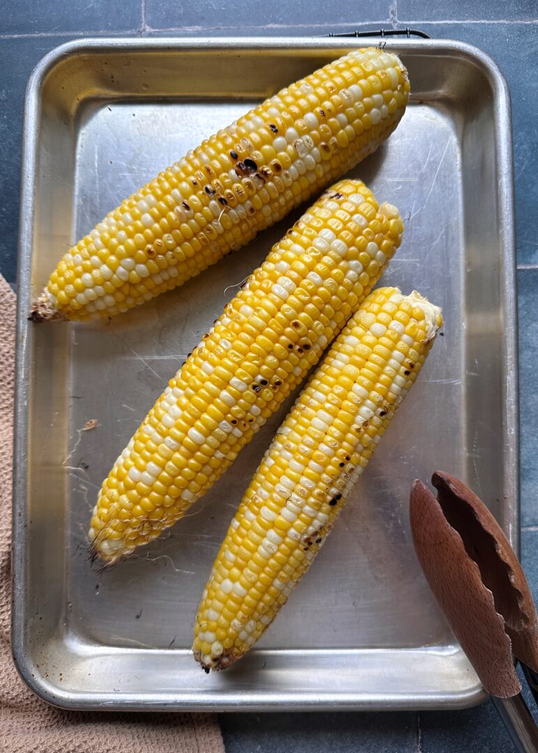grilled corn on the cob on silver tray