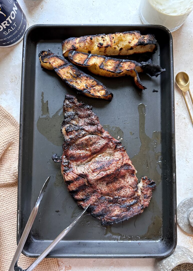 grilled ribeye steak and focaccia on a baking sheet