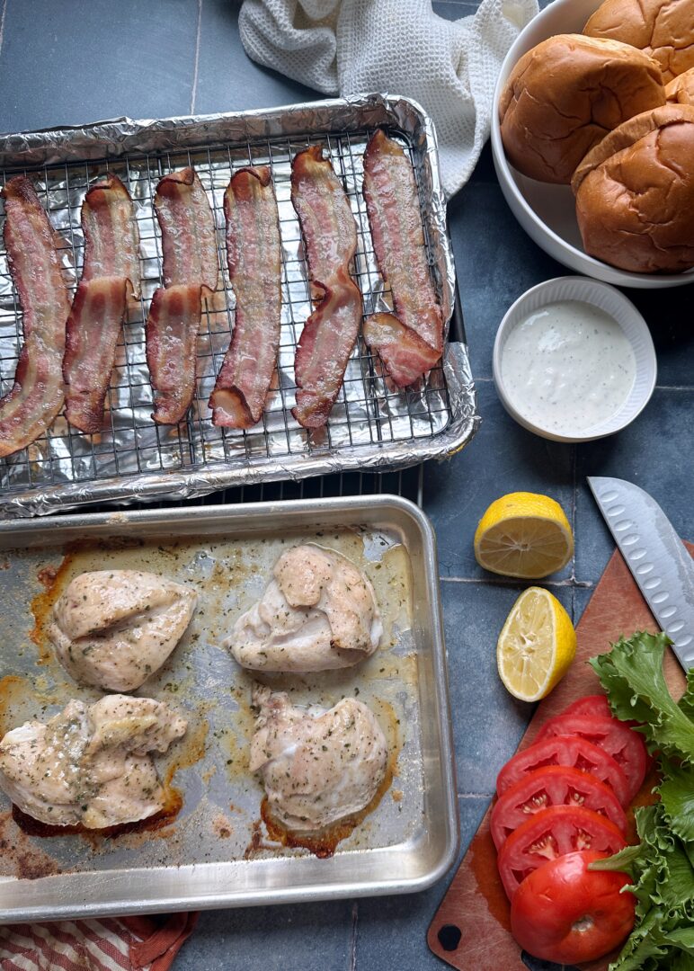 ranch seasoned chicken and slices of bacon on baking sheets