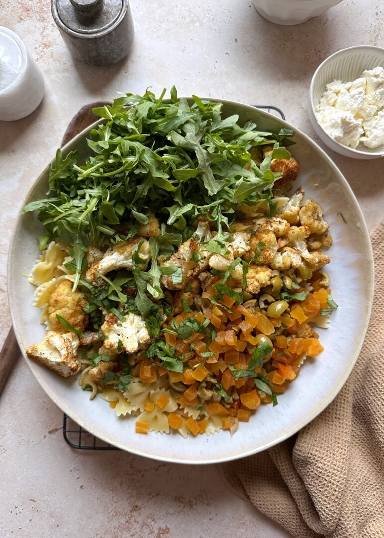 roasted cauliflower pasta salad ingredients in mixing bowl