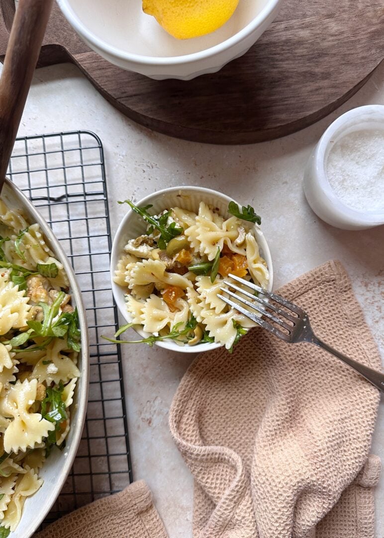 serving of roasted cauliflower pasta salad with olives apricots and arugula