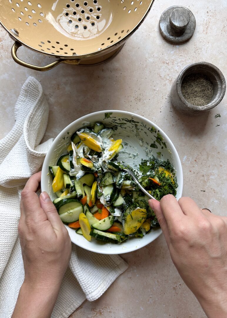 stirring carrot and cucumber salad ingredients together