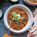 autumn harvest chili with sour cream and green onion garnish