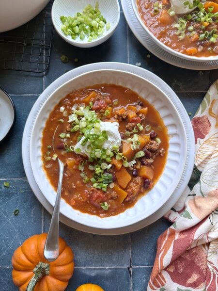 autumn harvest chili with sour cream and green onion garnish