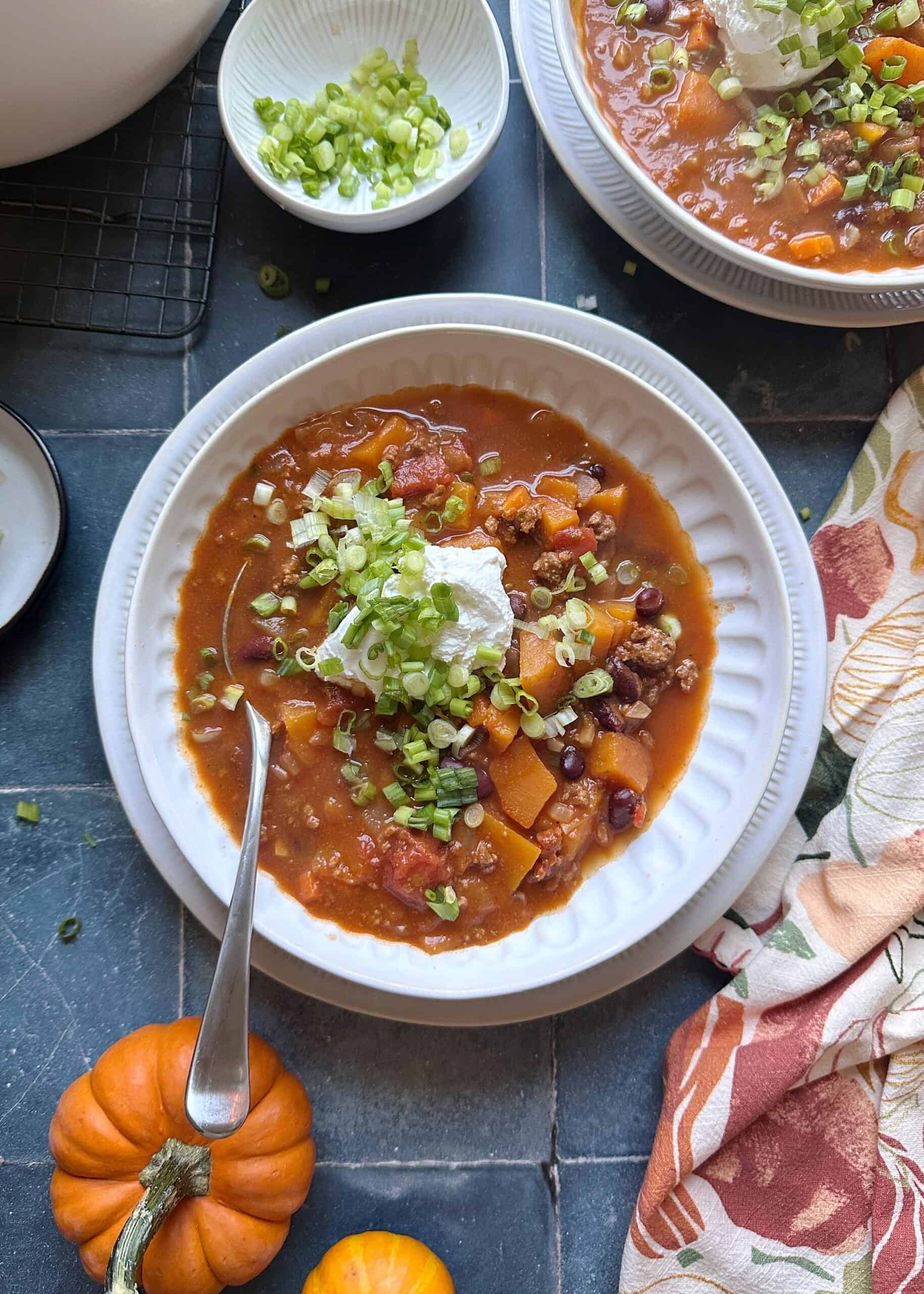 autumn harvest chili with sour cream and green onion garnish