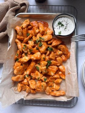 baked boneless buffalo wings on a silver tray with a side of ranch dressing