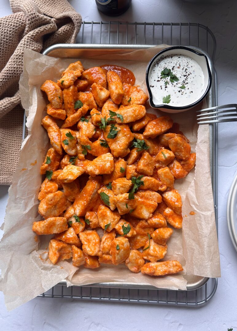baked boneless buffalo wings on a silver tray with a side of ranch dressing