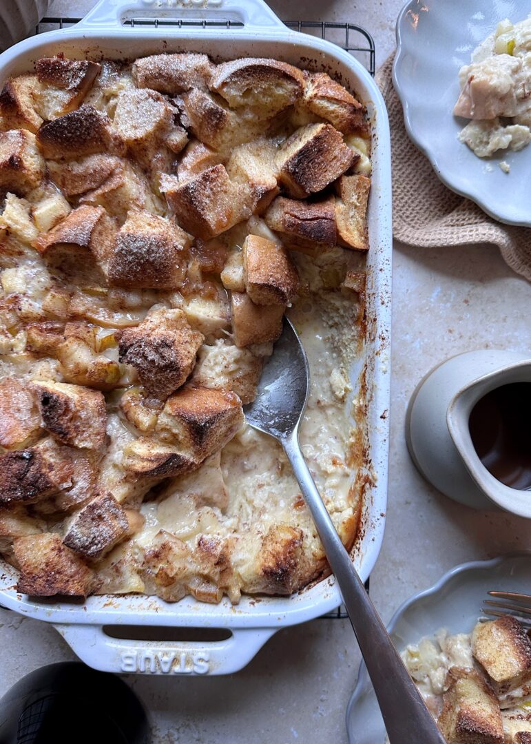 baked pear french toast in casserole dish with silver serving spoon
