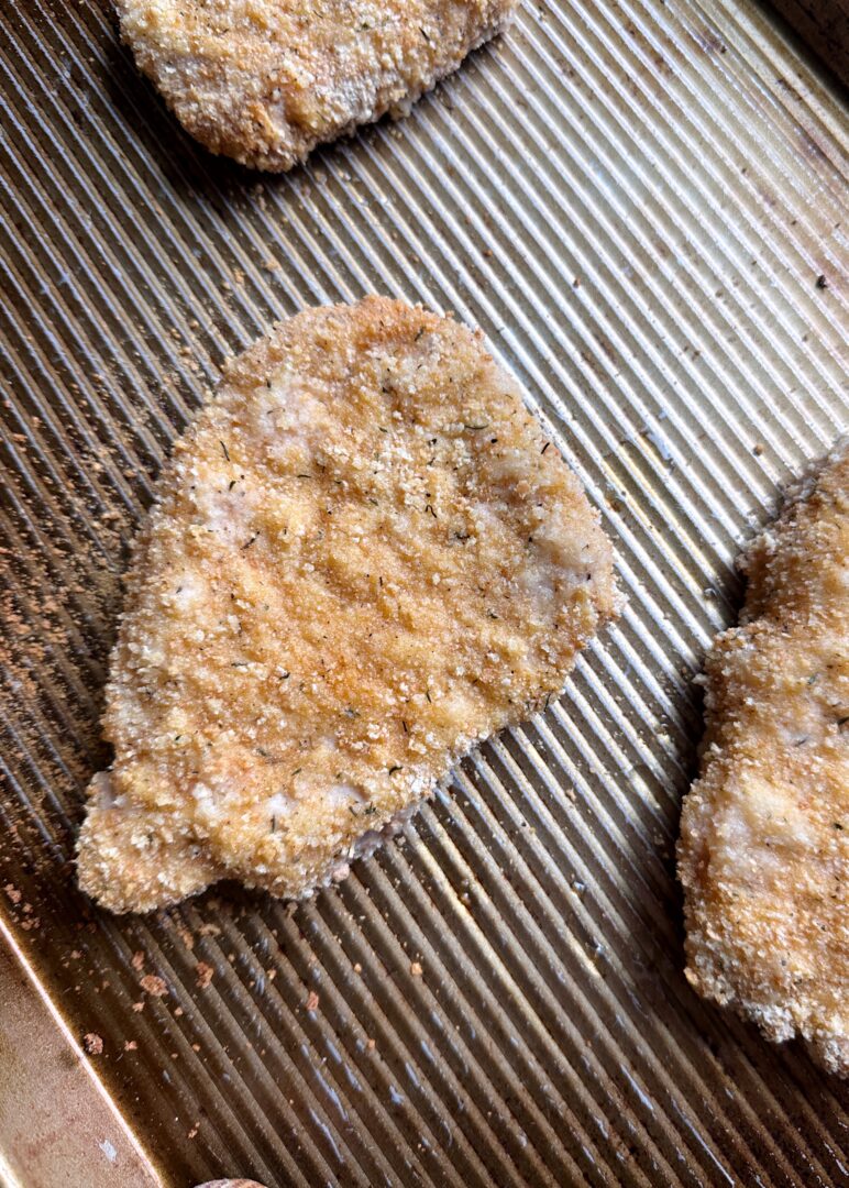 baked pork schnitzel on baking sheet
