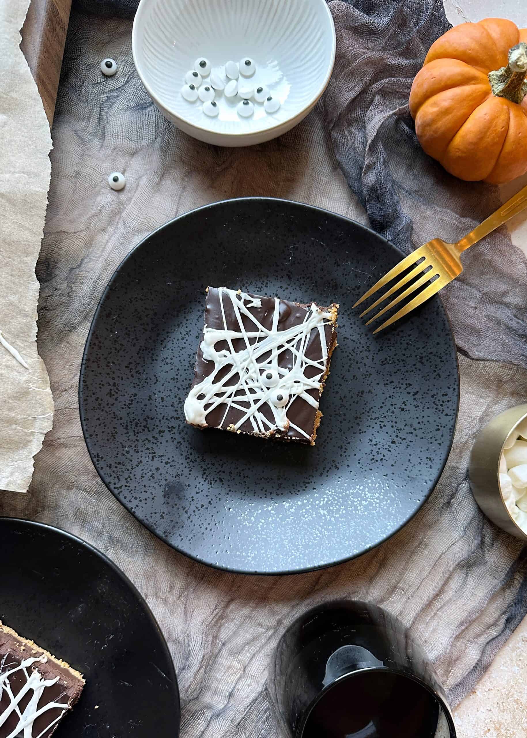 black plate with spiderweb smores bars