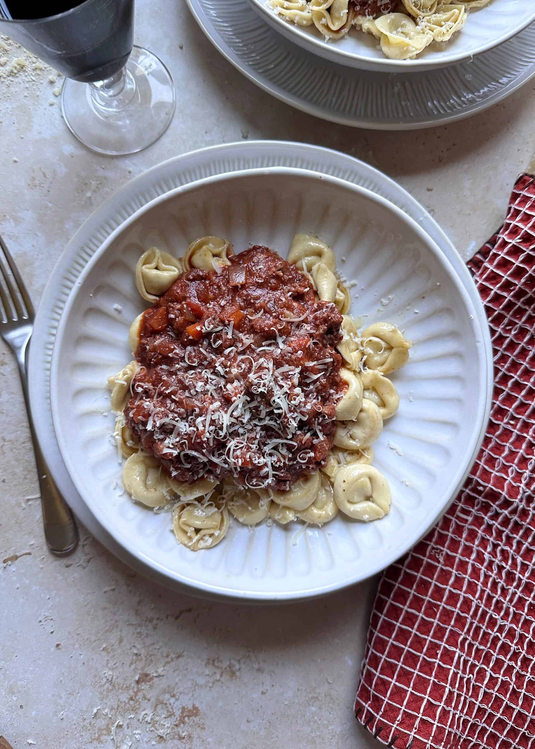 bowl of brown butter tortellini bolognese with parmesan