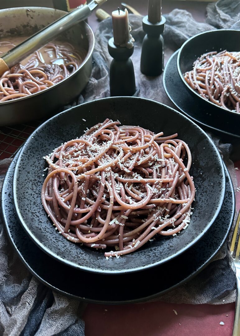 bowl of draculas red wine drunken pasta with parmesan cheese