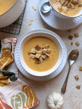bowl of pumpkin beer cheese soup with toasted chili maple chex