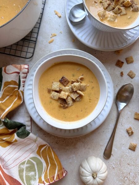 bowl of pumpkin beer cheese soup with toasted chili maple chex