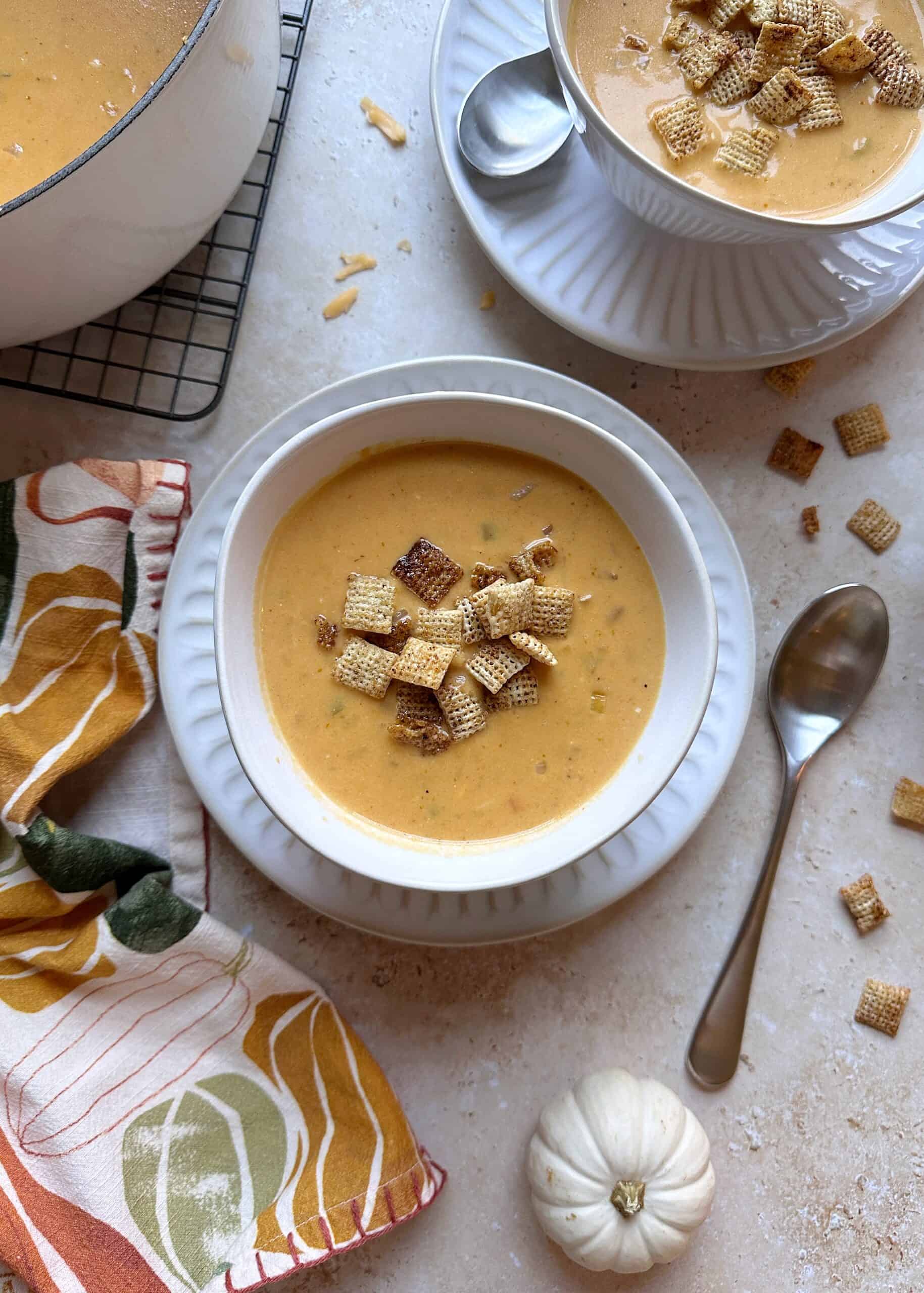 bowl of pumpkin beer cheese soup with toasted chili maple chex
