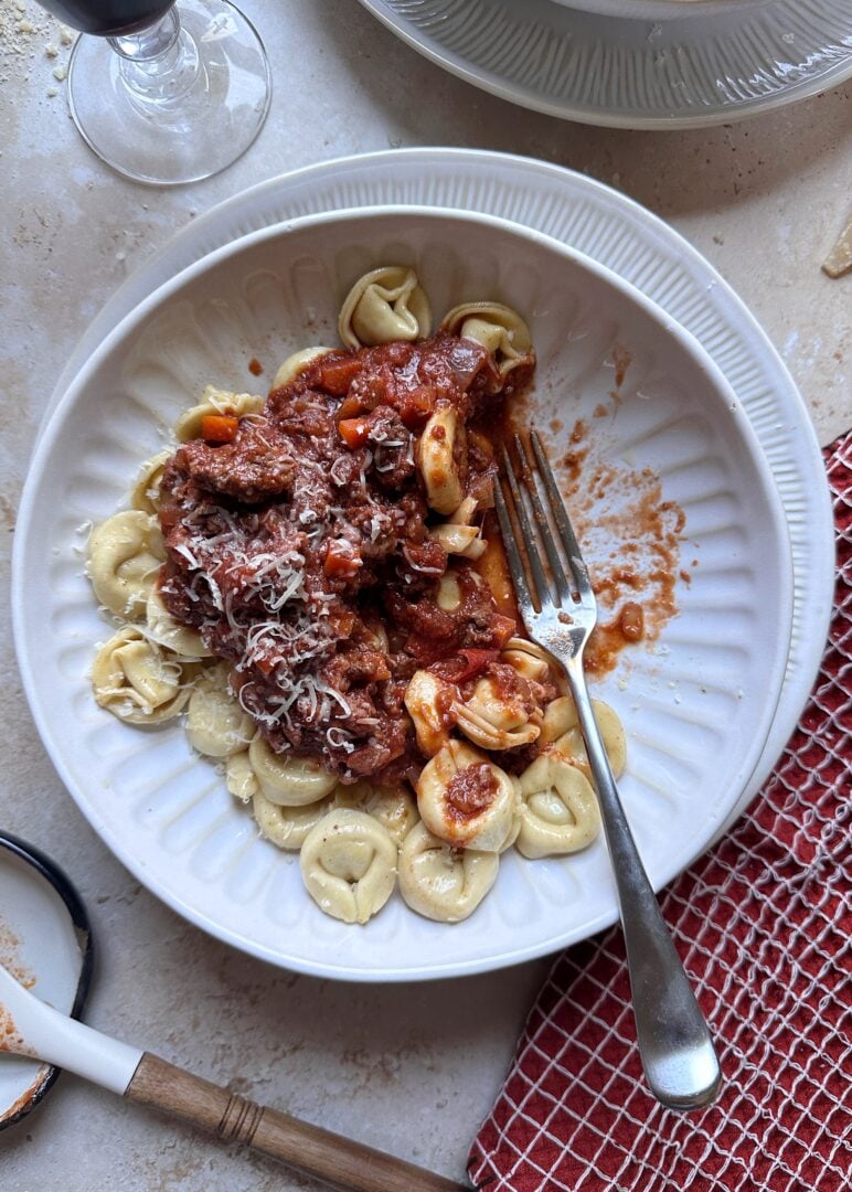 brown butter tortellini bolognese with fork