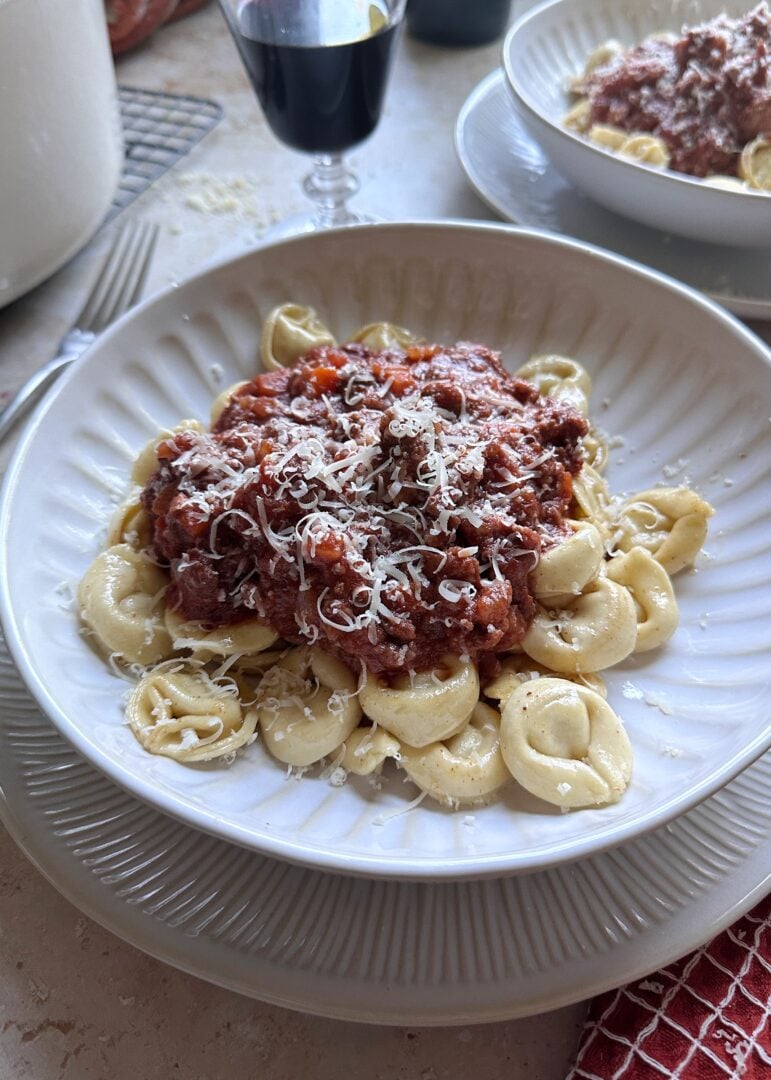 brown butter tortellini bolognese with parmesan on top