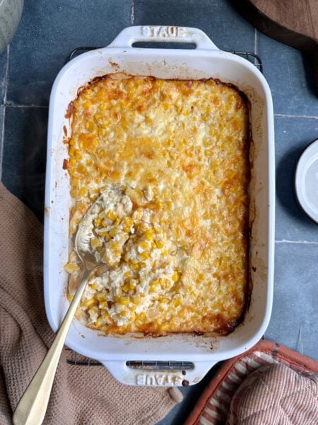 cheesy corn casserole with gold serving spoon