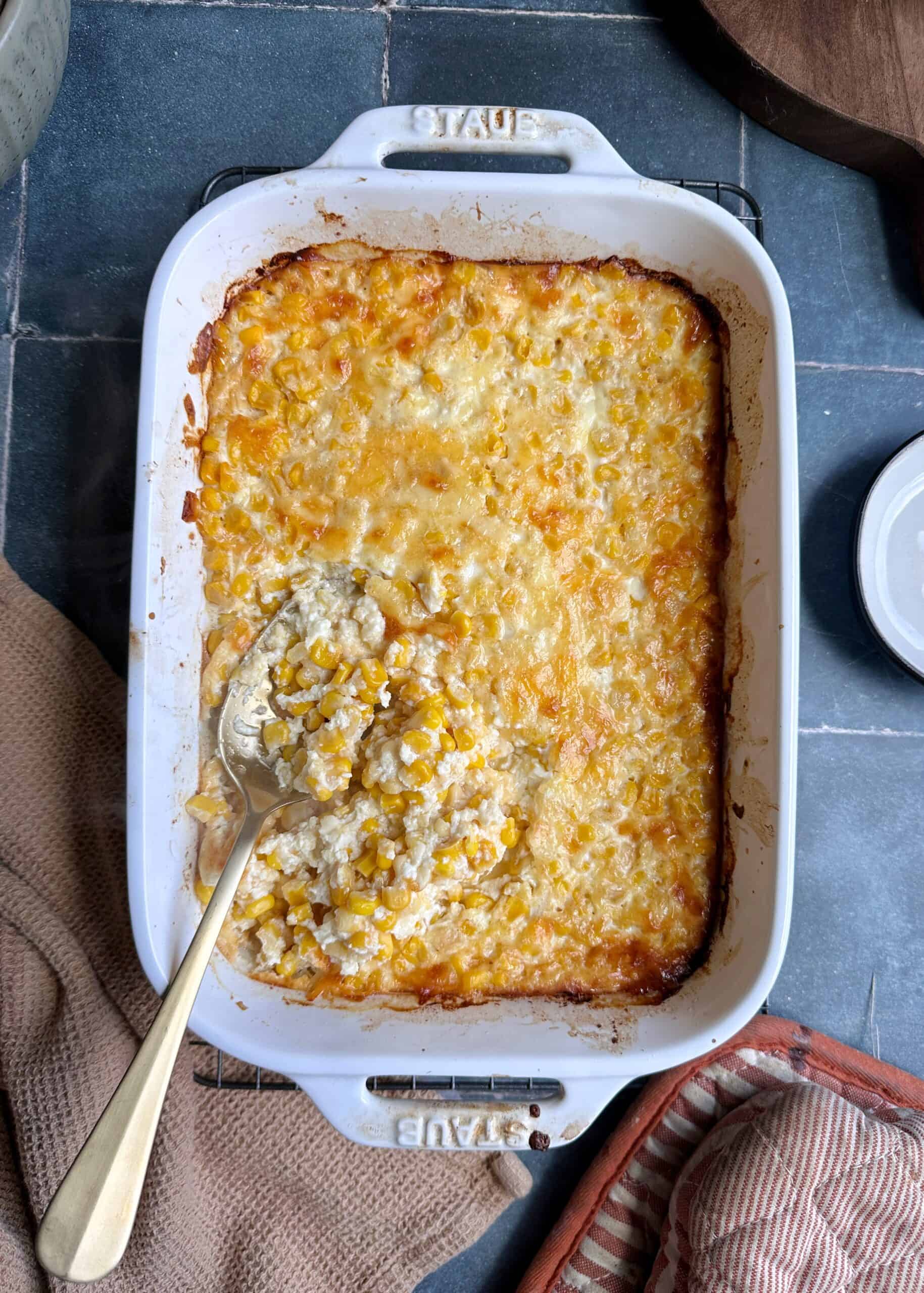 cheesy corn casserole with gold serving spoon