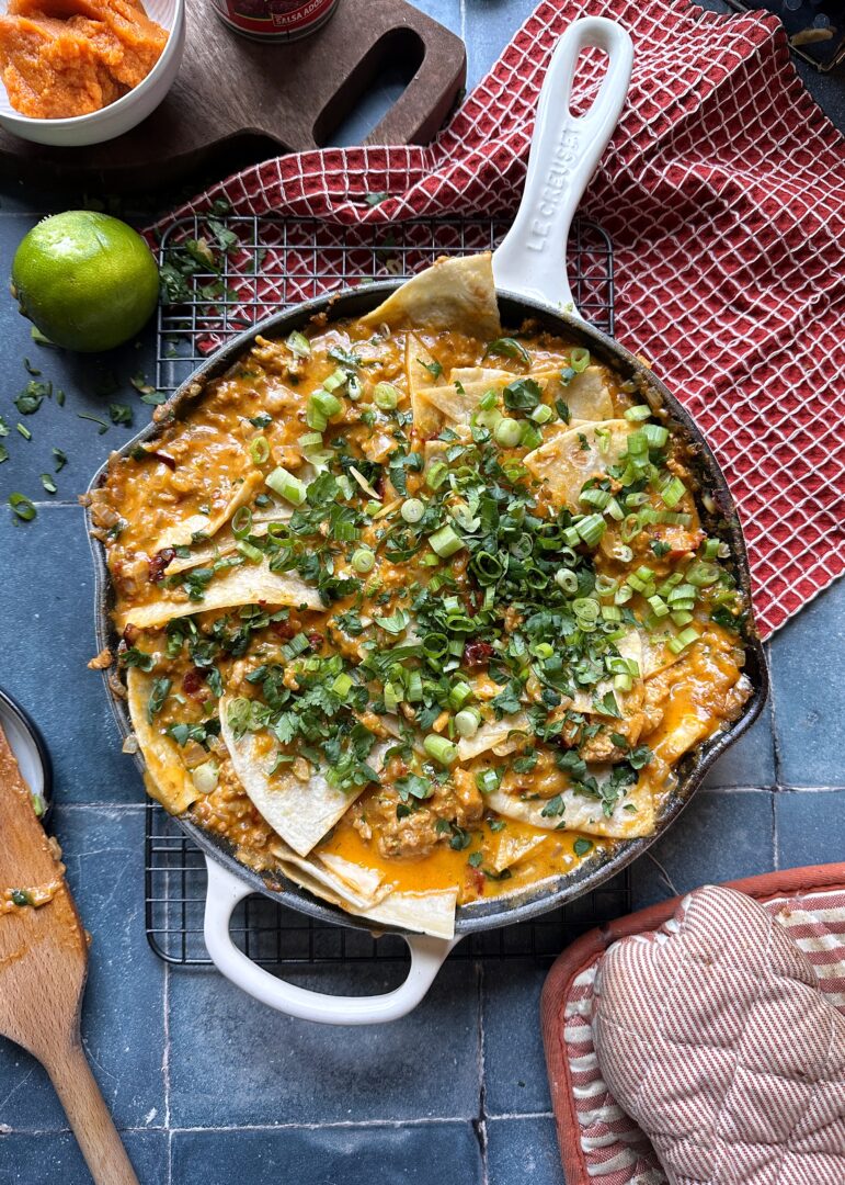 chipotle chicken enchiladas skillet with green onion and cilantro garnish