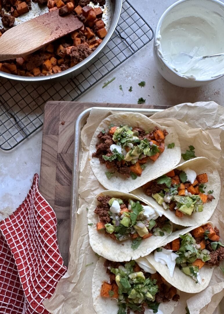 chorizo sweet potato tacos on a tray with a skillet of extra filling on the side