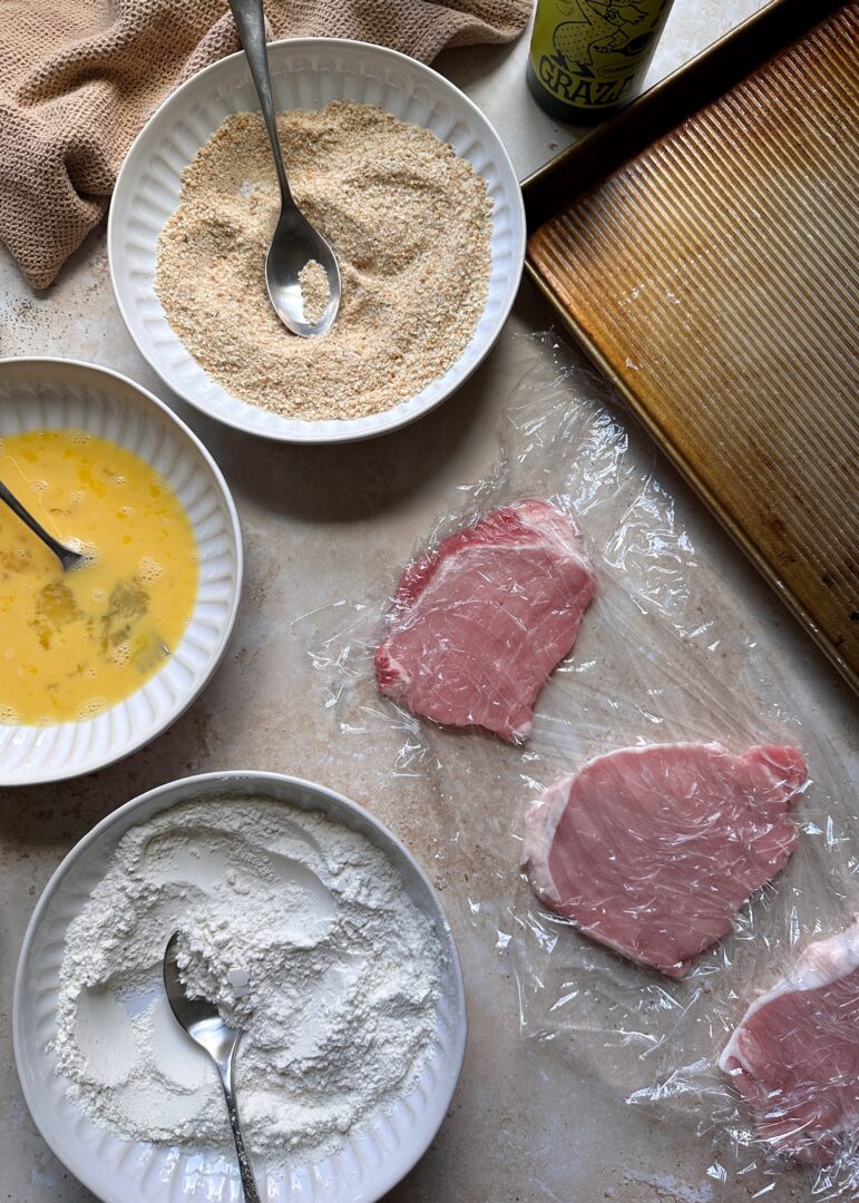 pork chops with bowls to begin breading them