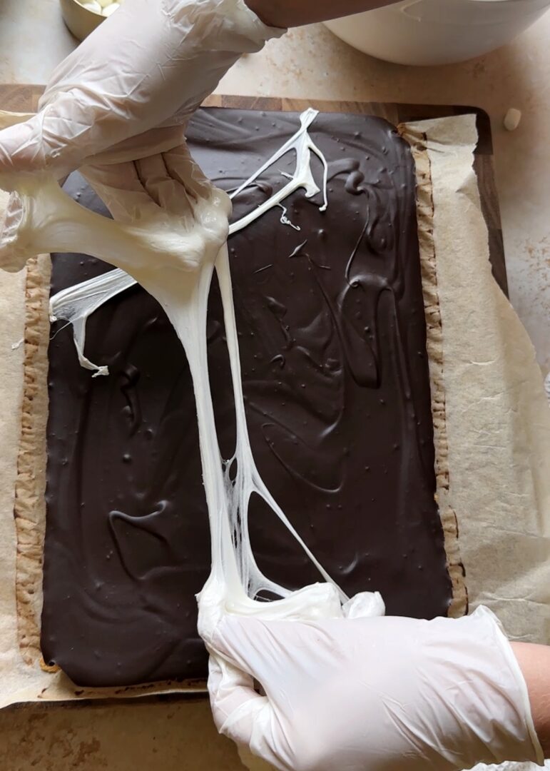 pulling marshmallows into spiderwebs