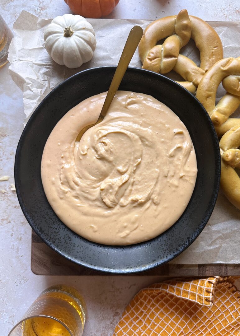 pumpkin beer cheese in black bowl with soft pretzels on the side