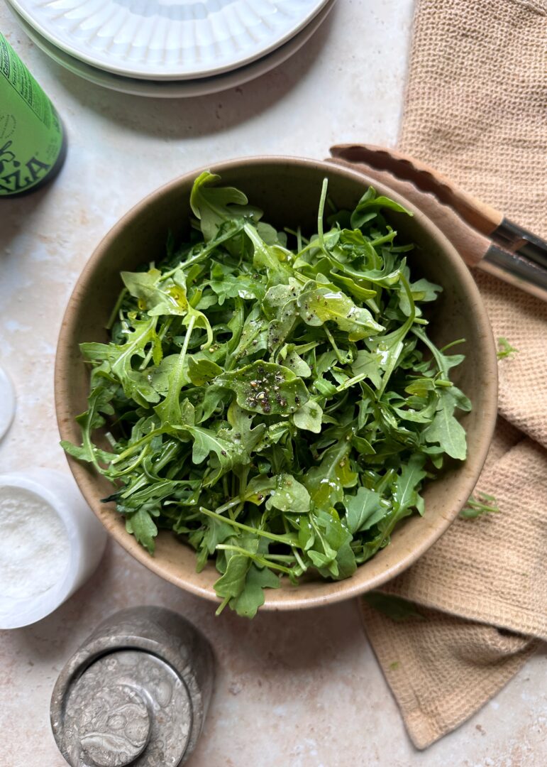 simple arugula salad in a mixing bowl