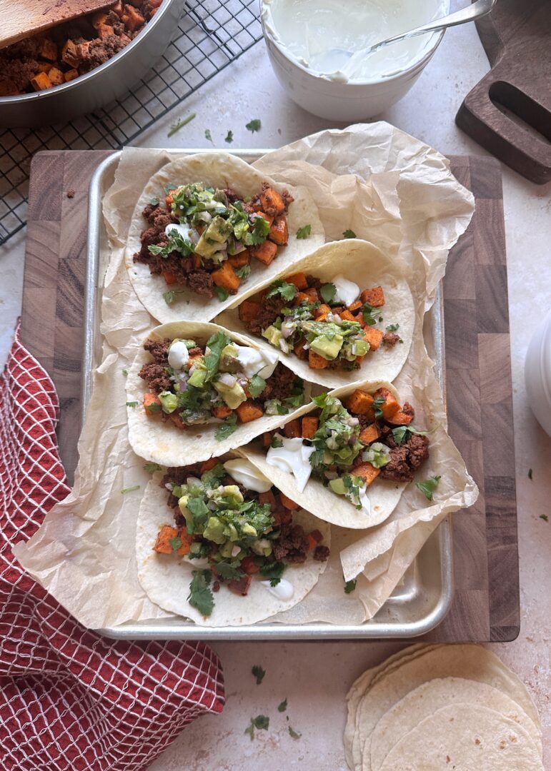 tray of chorizo sweet potato tacos with lime crema and avocado salsa
