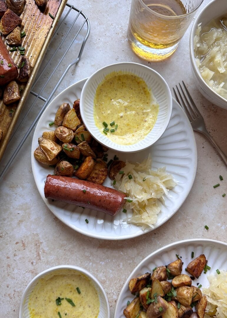 two roasted pieces of kielbasa with potatoes and honey mustard