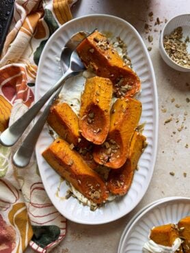 plate of roasted honeynut squash and goat cheese with silver serving spoon
