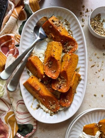 plate of roasted honeynut squash and goat cheese with silver serving spoon