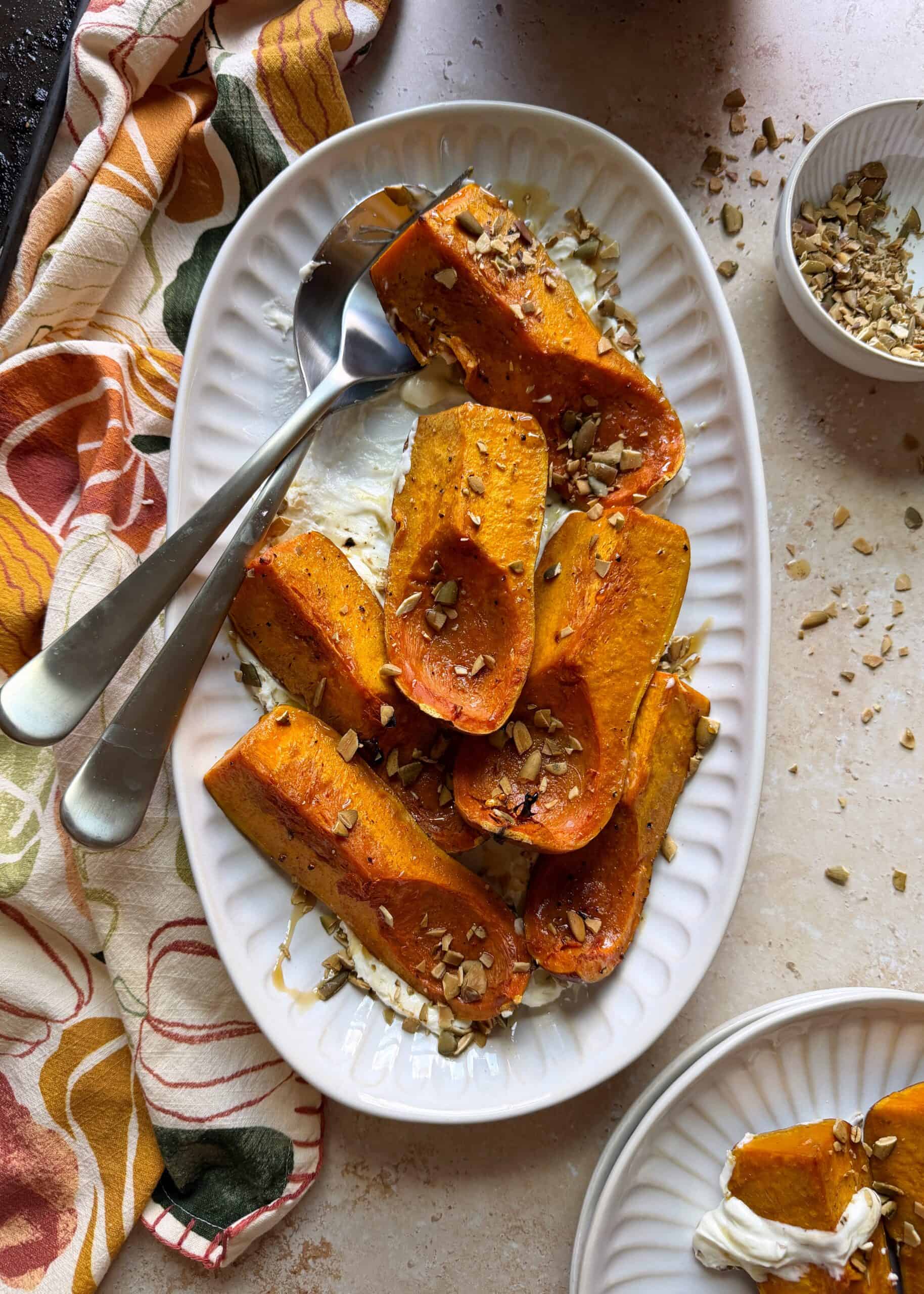 plate of roasted honeynut squash and goat cheese with silver serving spoon
