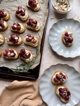 roasted grape crostinis with ricotta with plates on the side