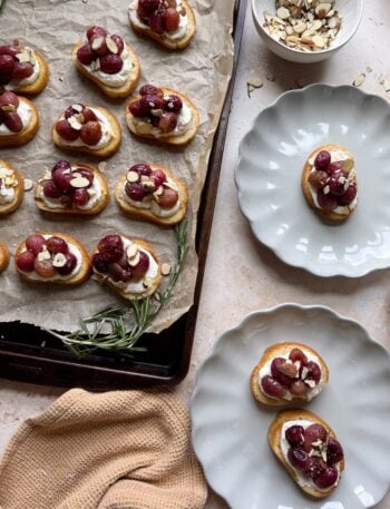 roasted grape crostinis with ricotta with plates on the side