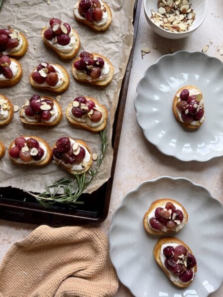roasted grape crostinis with ricotta with plates on the side