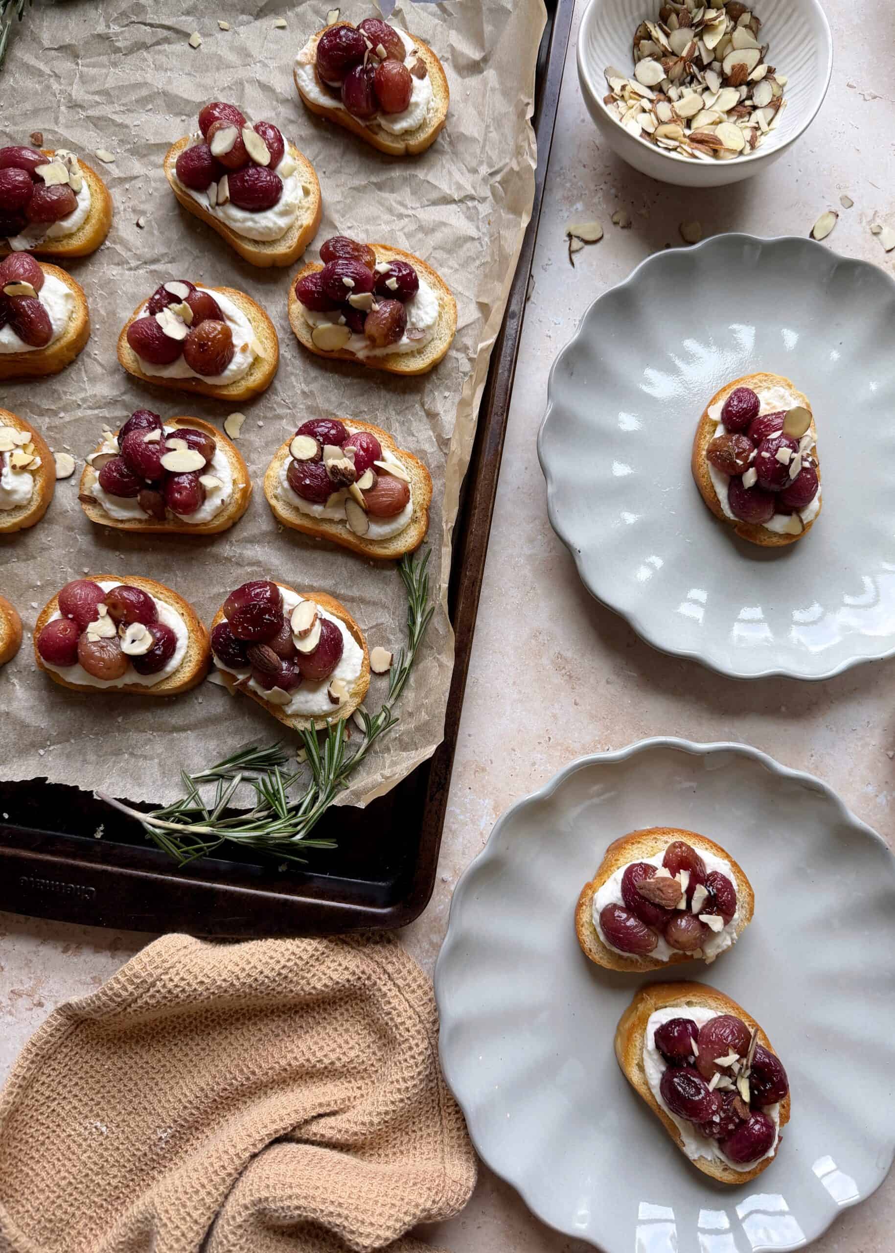 roasted grape crostinis with ricotta with plates on the side
